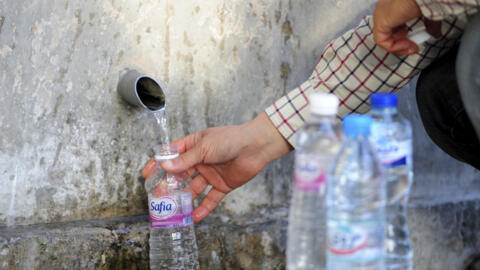 [Image d'archives] Un homme remplissant une bouteille d'eau potable à une source de Sidi Bou Saïd, au nord de Tunis, le 12 avril 2023.