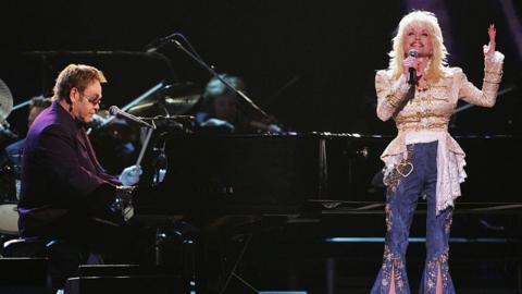 Elton John and Dolly Parton perform "Turn the Lights Out When You Leave" and "Imagine" (Photo by Michael Loccisano/FilmMagic for Country Music Association)

