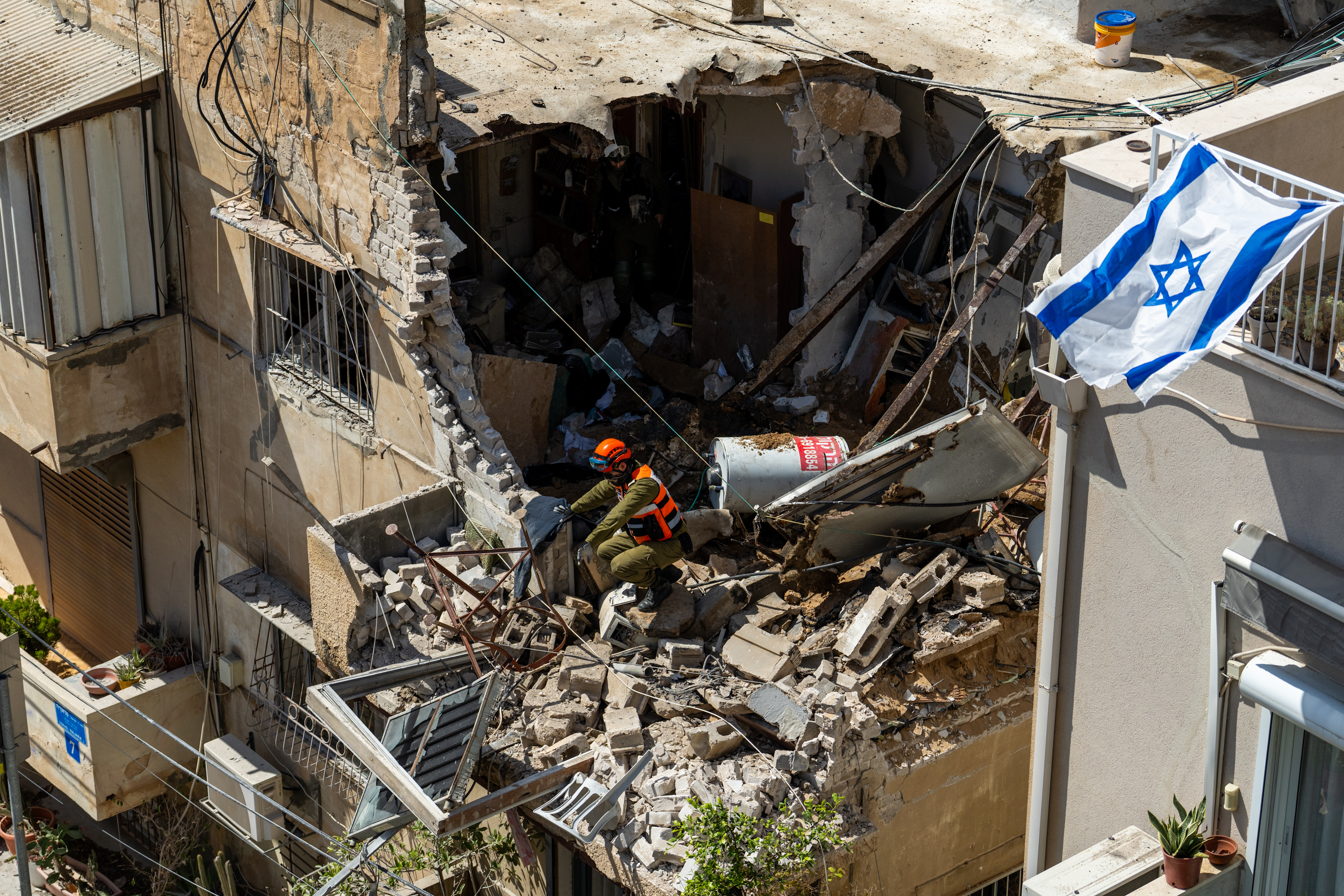 Israeli Home Front Command officers inspect an apartment building struck by an Iranian missile on March 22, 2026 in Tel Aviv, Israel. (Photo by Erik Marmor/Getty Images)