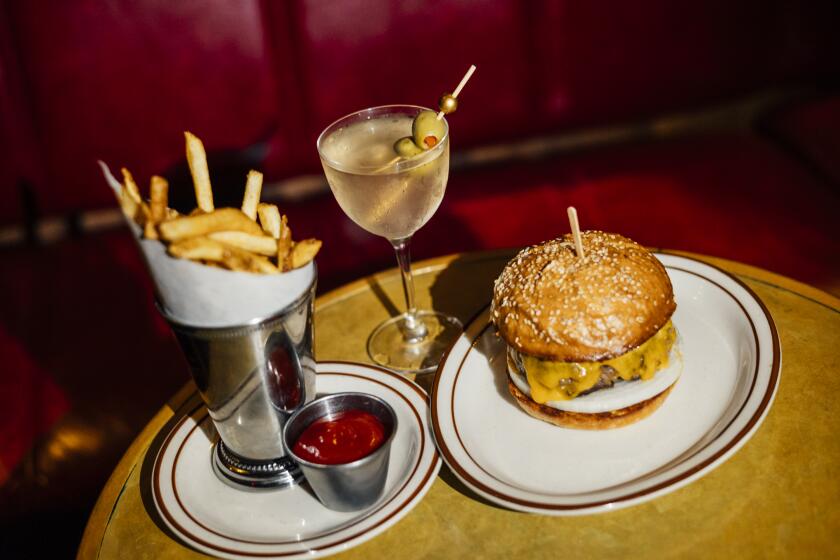 LOS ANGELES -- AUGUST 12, 2026: The Franklin Burger at Franklin Lounge with fries and a martini. (Chiara Alexa / For The Times)