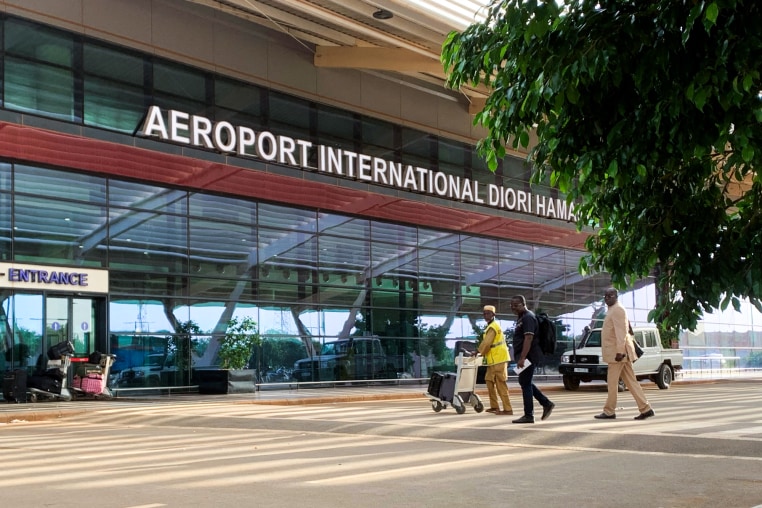 People walk on the crosswalk in front of Diori Hamani International Airport