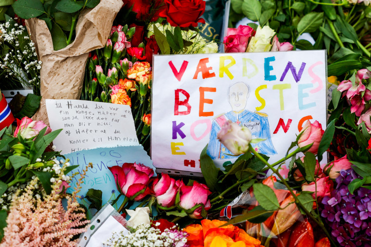 Flowers and children's drawings lay outside