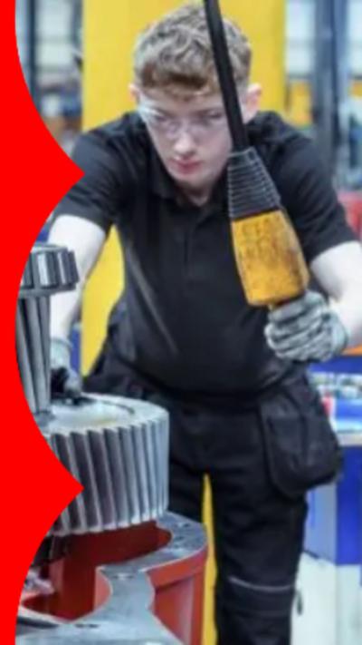 A young man with wavy  blond hair wearing safety goggles and using machinery.