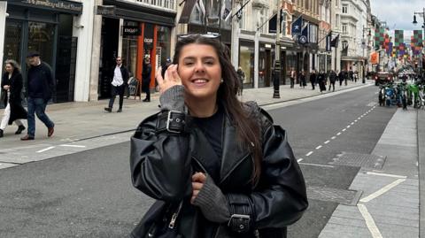 Ella Hewitt stands in a street