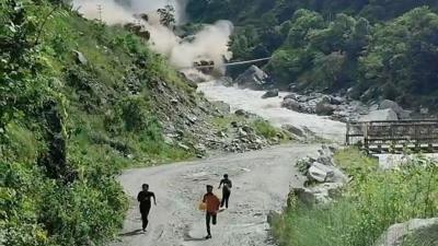 Men run from valley as water crashes down behind them 