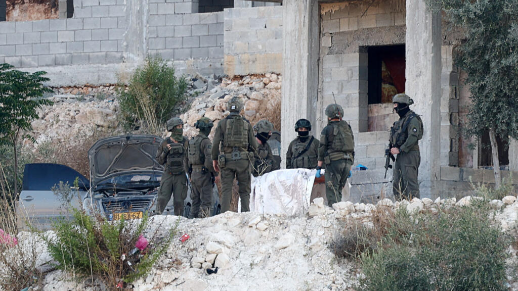 Israeli military forces carry the body of a Palestinian, following an Israeli military airstrike, in Jenin, in the Israeli-occupied West Bank, August 28, 2026. 