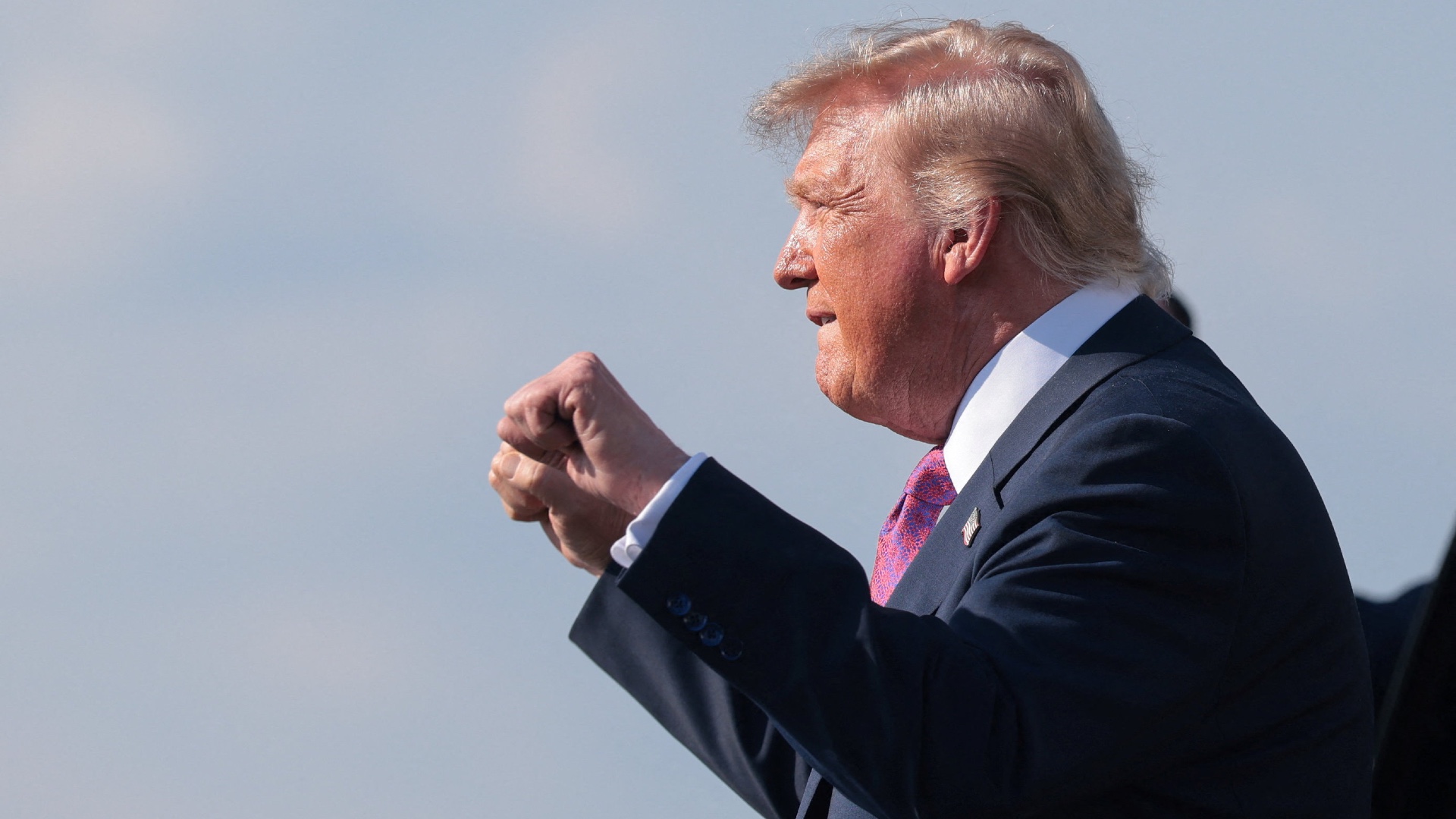 US President Donald Trump raises his fists to supporters after disembarking Air Force One at Ellington Field Joint Reserve Base in Houston, Texas, on 27 August 2026 (Kylie Cooper/Reuters)