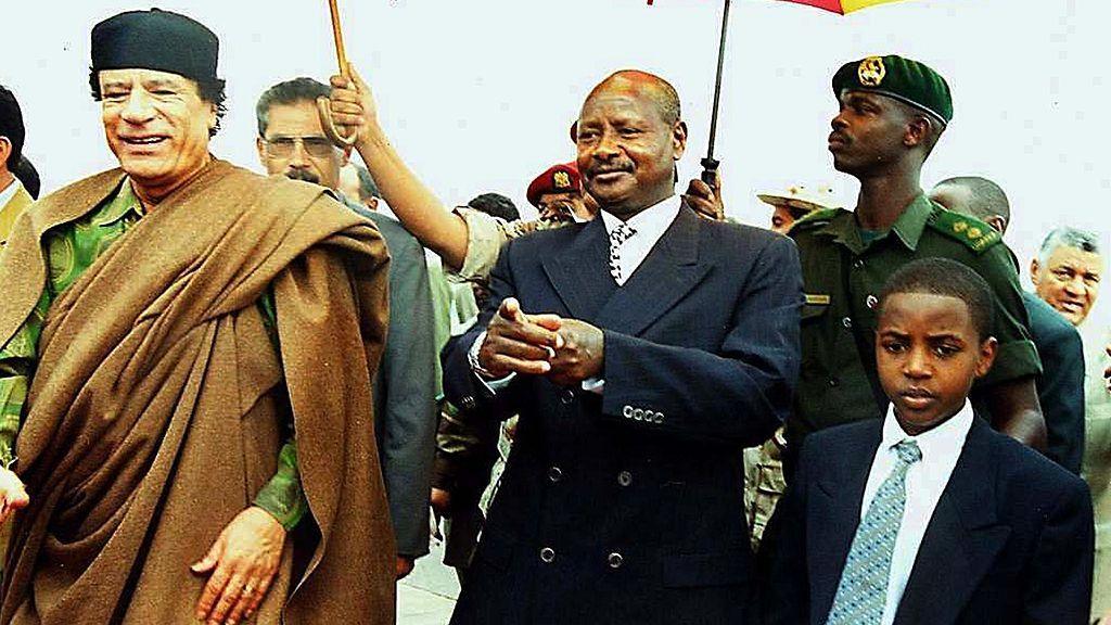 Libyan leader Moamer Khadafi  walks with Ugandan President Yoweri Museveni and young Toro King Oyo.