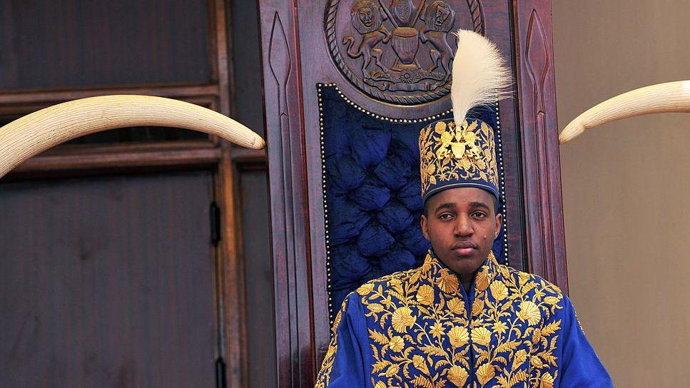 King Oyo pictured at 18 during his coronation wearing a gold embroidered jacket and hat. 