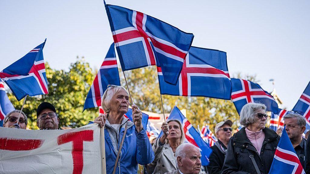 Supporters of the 'No' campaign wave Icelandic flags during a rally against reopening Iceland's European Union accession negotiations in Reykjavik, Iceland, on August 27, 2026