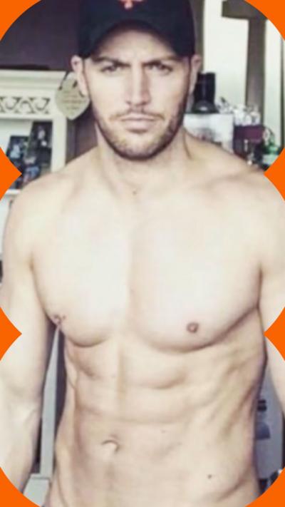 A shirtless man looks at the camera