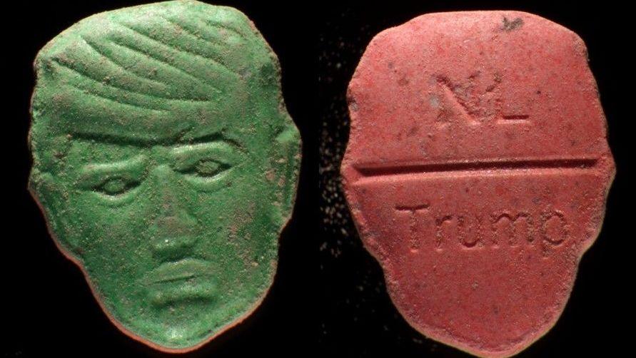 Front and back picture of an ecstasy pill in the shape of US President Donald Trump's head. The green front is a depiction of Trump's face carved into the pill; the back, in red, features the word "NL" carved at the top of a break line under which is stamped the word "Trump"