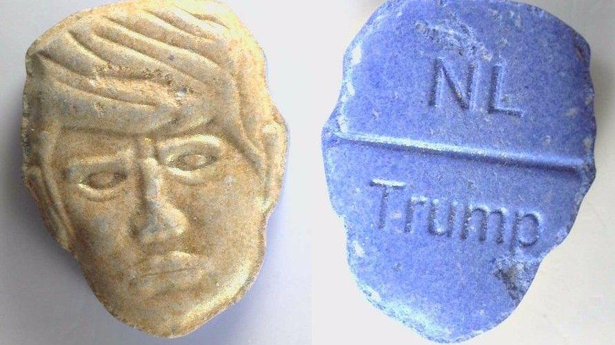 Composite pictures of two versions of the same pill. At the top is the front and back picture of an ecstasy pill in the shape of US President Donald Trump's head. The green front is a depiction of Trump's face carved into the pill; the back, in red, features the word "NL" carved at the top of a break line under which is stamped the word "Trump". 
At the bottom of the image is the same pill but in yellow and blue