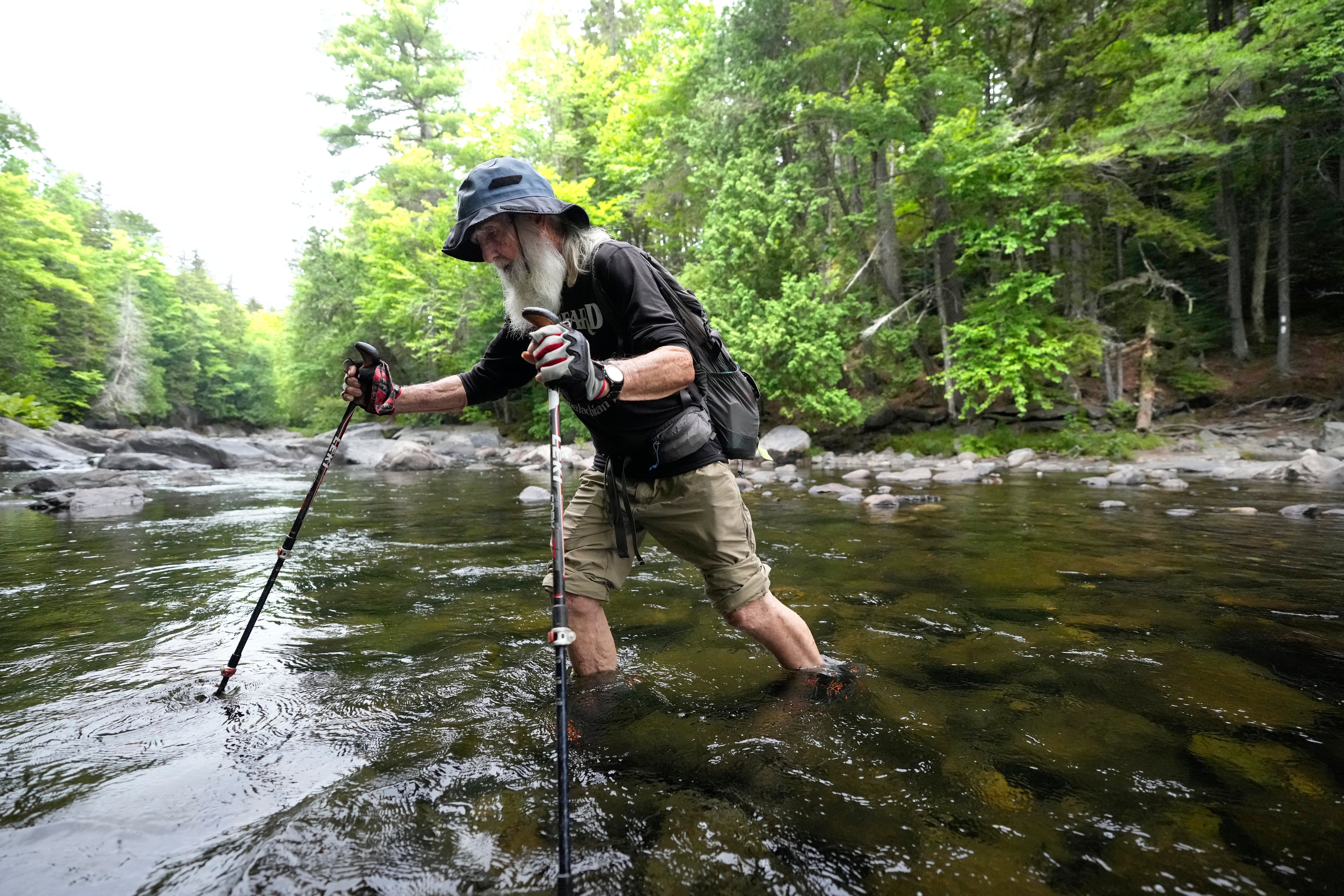 Sanders wades across Big Wilson Stream on the 100-Mile Wilderness north of Monson