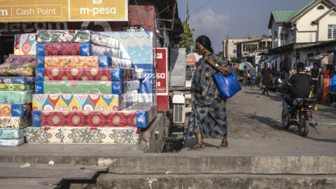 Une femme passant devant une boutique à Kinshasa, en décembre 2023.