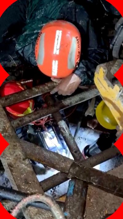 A rescuer digs through wreckage