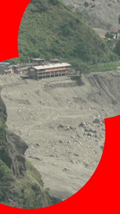 Image of a valley in Rasuwa with rumble and debris from floods and a building still standing