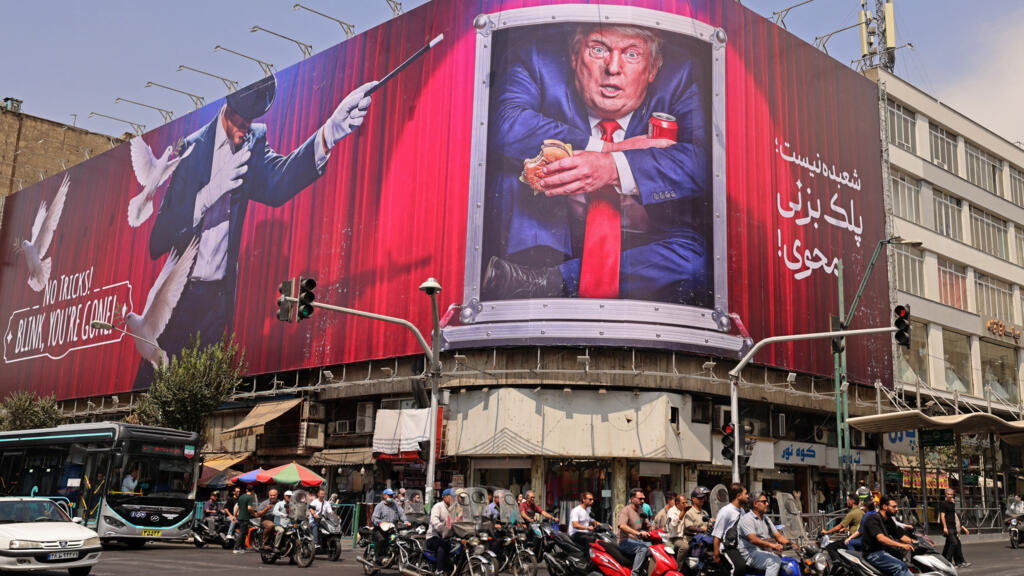 Motorists ride past a billboard depicting US President Donald Trump inside a catering container, installed on a building along a street in downtown of Tehran on August 31, 2026