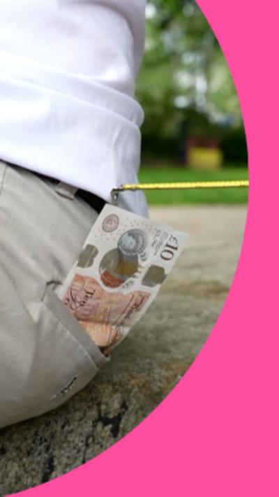 A £10 note sticking out of someone's back pocket with a tape measure attempting to steal it.