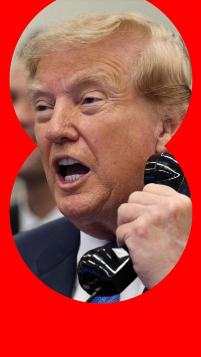 US President Donald Trump is holding up a telephone receiver and talking.