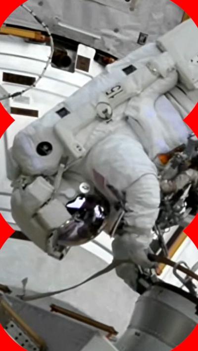 An astronaut in a spacesuit floats upside down on a spacewalk outside their vehicle.