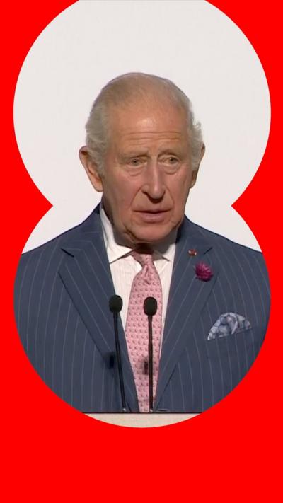 King Charles III in front of Union Jack flags