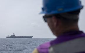 Navy secretary calls reports of Lincoln crew struggles ‘dishonest’ A sailor aboard a guided-missile destroyer observes an aircraft carrier.