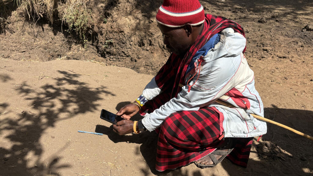 Loother, un Masaai qui mesure une empreinte de hyènes près du village de Mswakini.