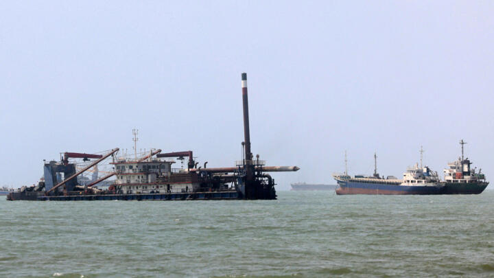 File photo of a vessel moving past a barge along the Strait of Hormuz off Bandar Abbas in southern Iran taken August 10, 2026.