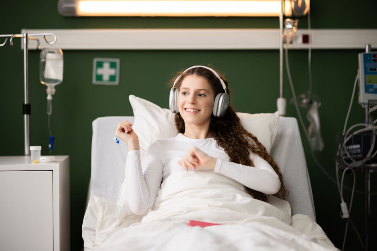 patient wears headphones in her hospital bed