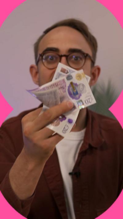 A man wearing glasses holds notes up to the camera