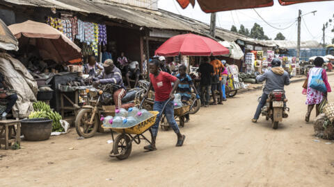 Un garçon poussant une brouette avec des bouteilles d'eau sur un marché de Bamenda, le 12 avril 2026. [Image d'illustration]