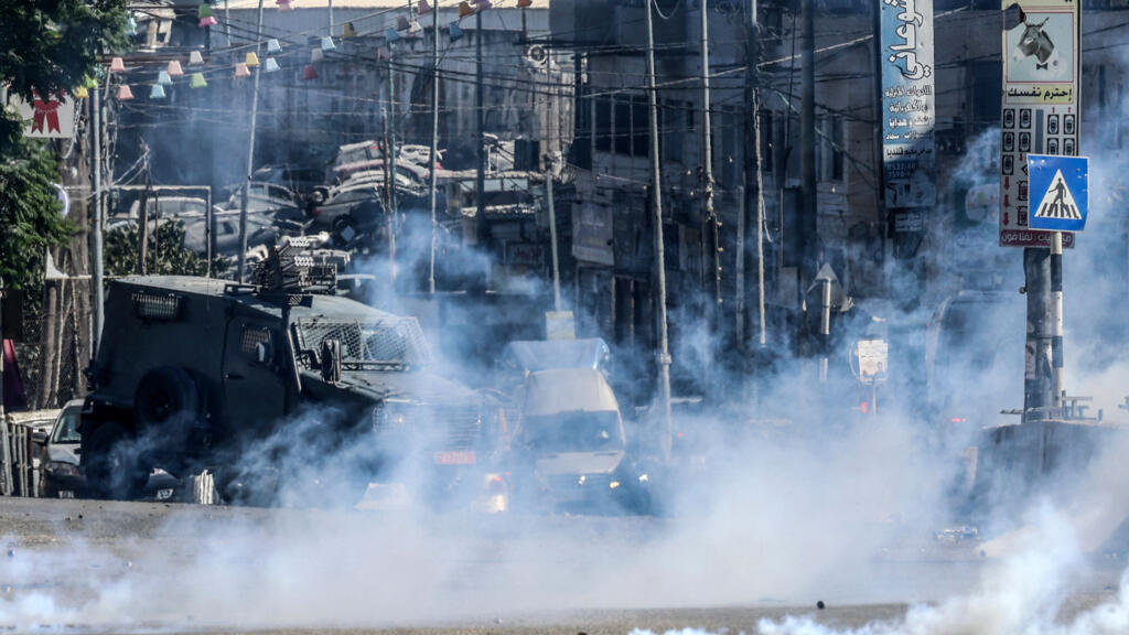 Israeli forces block a street and fire tear gas during an Israeli raid between the Kafr Aqab neighbourhood and the Qalandia refugee camp, south of the West Bank city of Ramallah, on August 25, 2026.