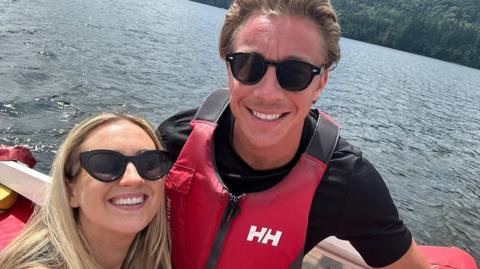 Molly and Taylor Haylett on a boat in the water smiling 