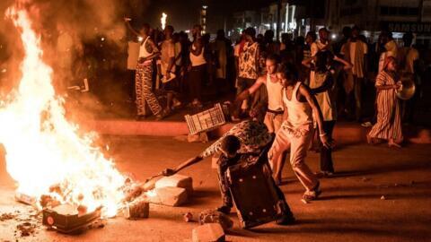 Des manifestants brûlent des pneus et bloquent une route lors d'une manifestation contre la crise électrique qui sévit dans le pays et les coupures de courant persistantes à Brusubi, en Gambie, le 8 septembre 2026.