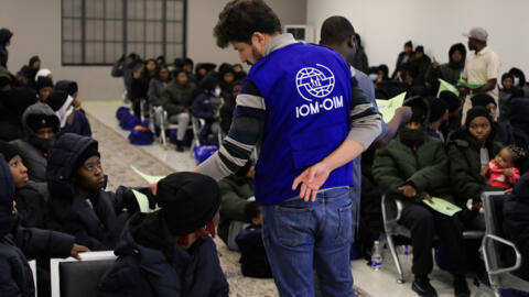 Un responsable de l'Organisation internationale pour les migrations (OIM) s'entretient avec des migrants nigérians avant leur expulsion de Tripoli, en Libye, le 18 mars 2025.