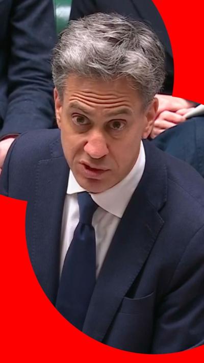 A man with grey hair in a blue suit, white shirt and blue tie.