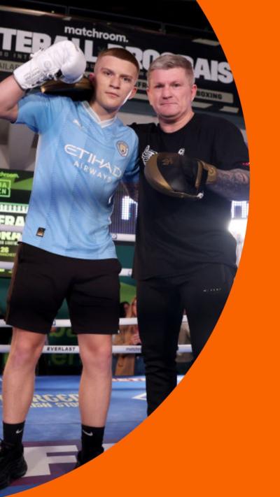 Campbell Hatton stands next to his dad boxer Ricky Hatton in a boxing ring.