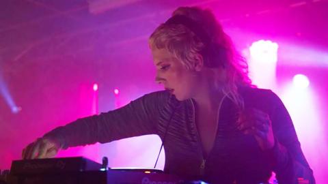 Julia Dunne is on the decks, backed by pink lighting