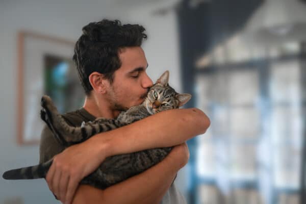 Man kissing his pet cat