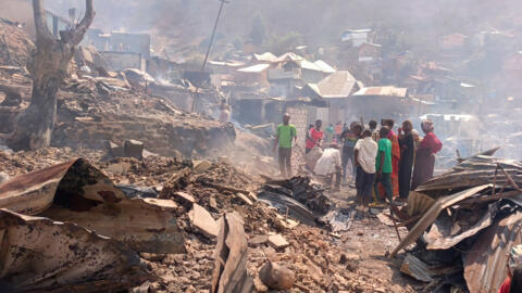 Des personnes traversent un nuage de fumée après un incendie survenu dans une école et qui a fait plusieurs victimes à Bukavu, au Congo, le jeudi 10 septembre 2026.