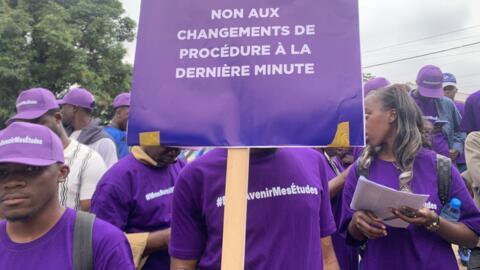 Un étudiant camerounais avec une pancarte pour dénoncer le durcissement des conditions de délivrance de visas aux étudiants admis dans les universités privées en France, à Yaoundé le 14 juillet 2016.
