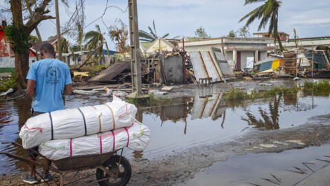 Un habitant s'appuie sur une charrette près des bâtiments détruits de la ville de Toamasina, sur la côte est de Madagascar, frappée par le cyclone tropical Gezani le 11 février 2026.