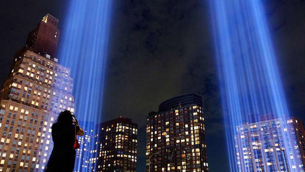  A woman takes a photograph of the two beams of light that make up the Tribute in Light as it is illuminated over lower Manhattan ahead of the 25th anniversary of the attack on the World Trade Center on September 09, 2026, in New York City.

