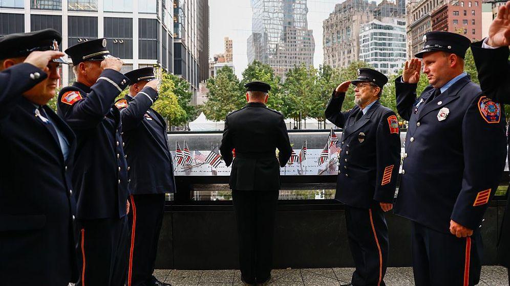 Fire Department of New York (FDNY) firefighters pay their respects at the memorial before a ceremony to commemorate the 25th anniversary of the September 11th terrorist attacks on the World Trade Center
