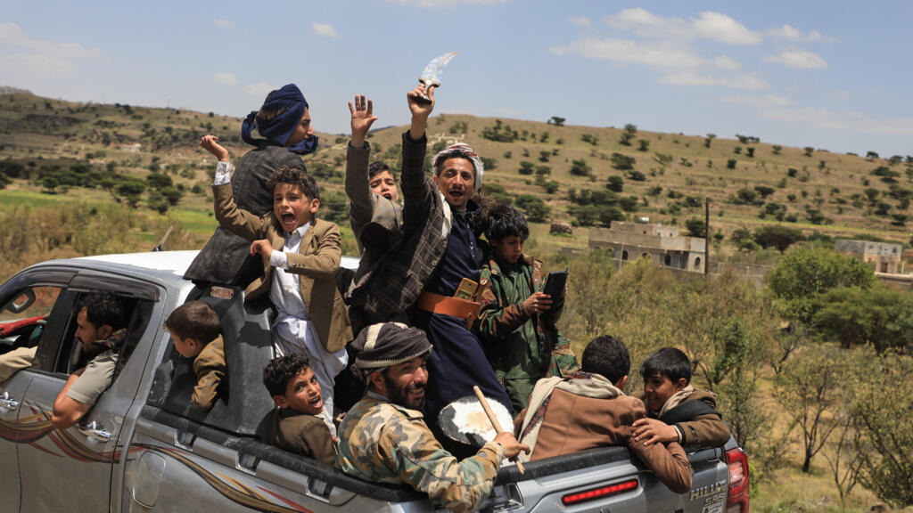 Yemeni civilians celebrate while riding in the back of a pickup truck in the Bani Matar district, Yemen, September 12, 2026, as they follow a convoy carrying Houthi prisoners freed in Mokha.