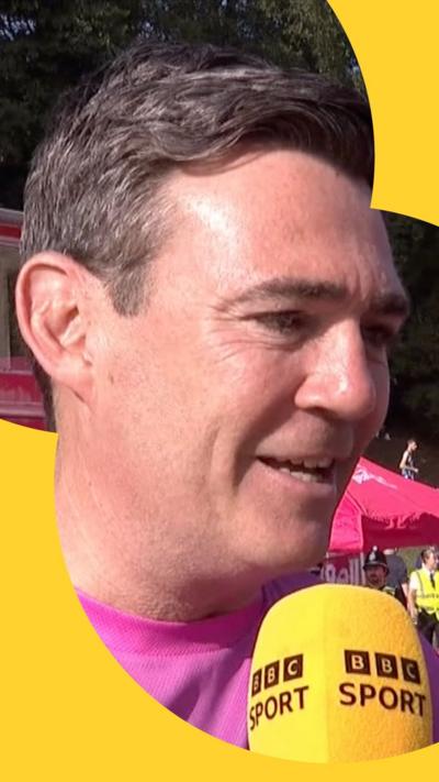 Andy Burnham with a yellow BBC Sport microphone in front of him