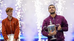Carlos Alcaraz, of Spain, holds the championship trophy as Jannik Sinner, of Italy, looks on after Alcaraz defeated Sinner in the men's singles final of the U.S. Open on Sunday, Sept. 7 in NY.