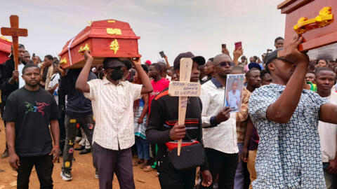 Des personnes assistent à une cérémonie funéraire en hommage aux écoliers décédés lors d'un incendie qui a ravagé deux écoles de la ville de Bukavu, dans l'est de la République démocratique du Congo, le lundi 14 septembre 2026.