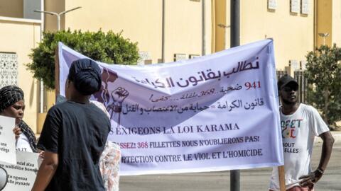 Des militants brandissent une banderole en faveur de la loi Karama lors d'une manifestation contre les féminicides devant l'Assemblée nationale à Nouakchott, le 1er mai 2026. (Image d'illustration)